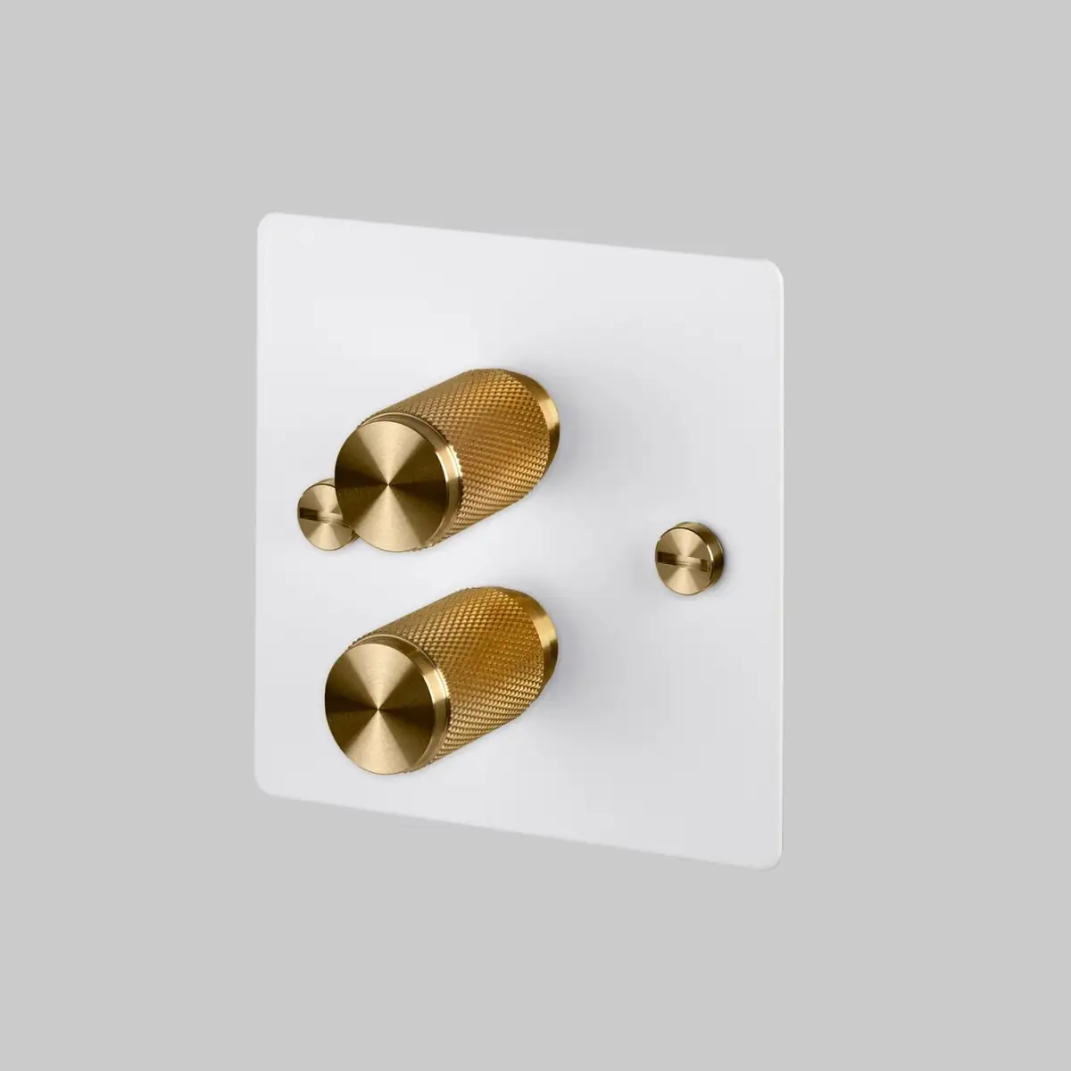 White plate with two dimmers with knurled brass knobs