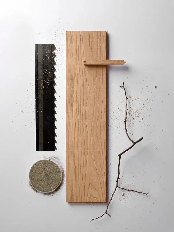 Oak board with saw marks and sandblasting next to a saw blade and a sand disc.