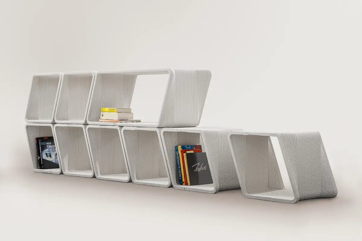Estantería modular impresa en 3D formada por módulos apilados, con libros, fotografiada en estudio.