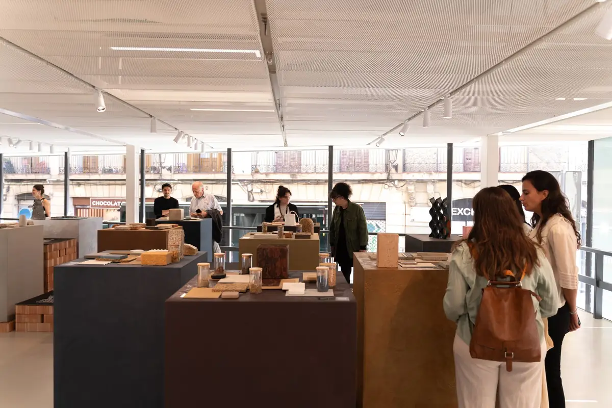 Visitantes ante las peanas con muestras de materiales de la exposición Materialidad Contemporánea en el altillo del COAC.