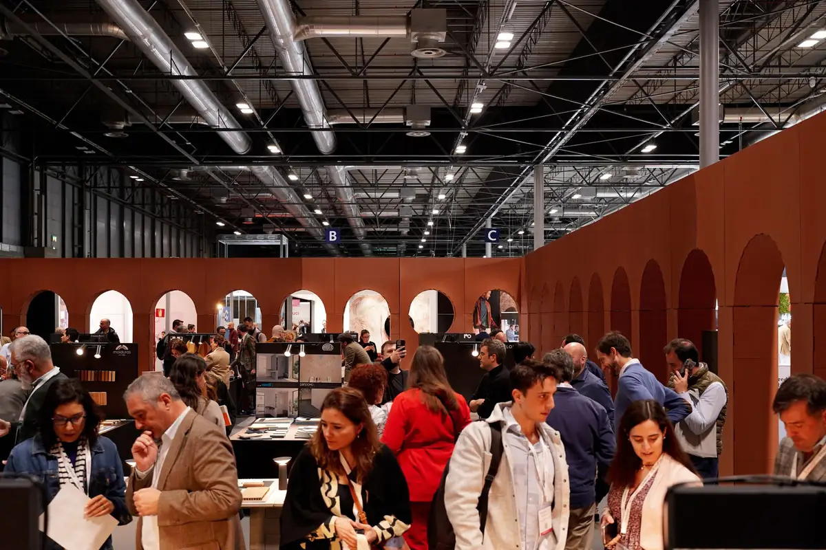 Visitantes recorriendo el stand de Matter, con muros y arcos de color terracota, en un pabellón de IFEMA