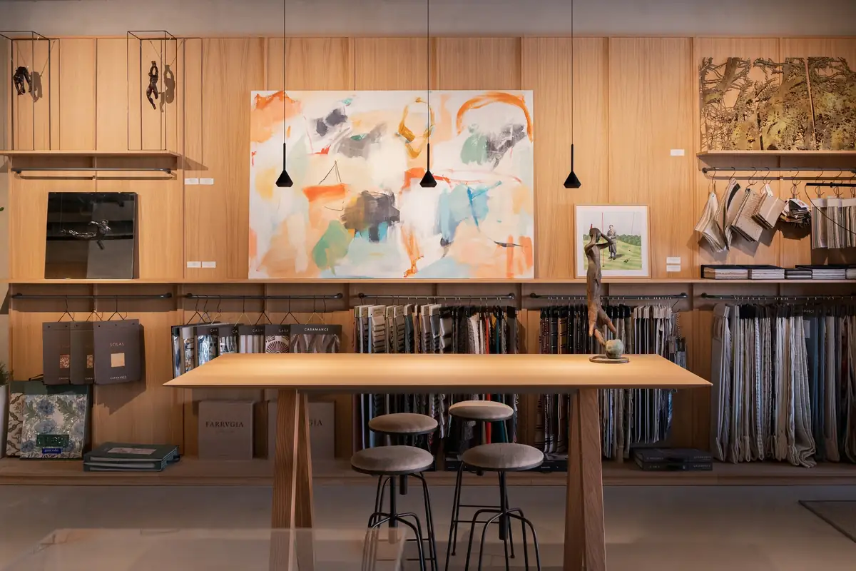High table with stools in front of the textile library and a large painting