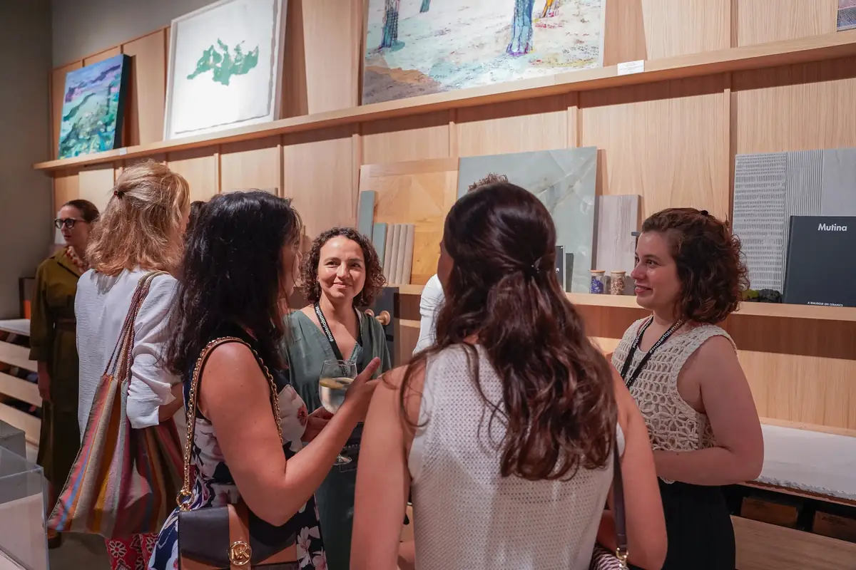 Guests talking next to the sample shelves and the artwork on display
