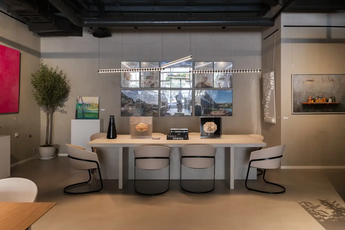 Meeting room with a pale table, chairs and screens on the back wall