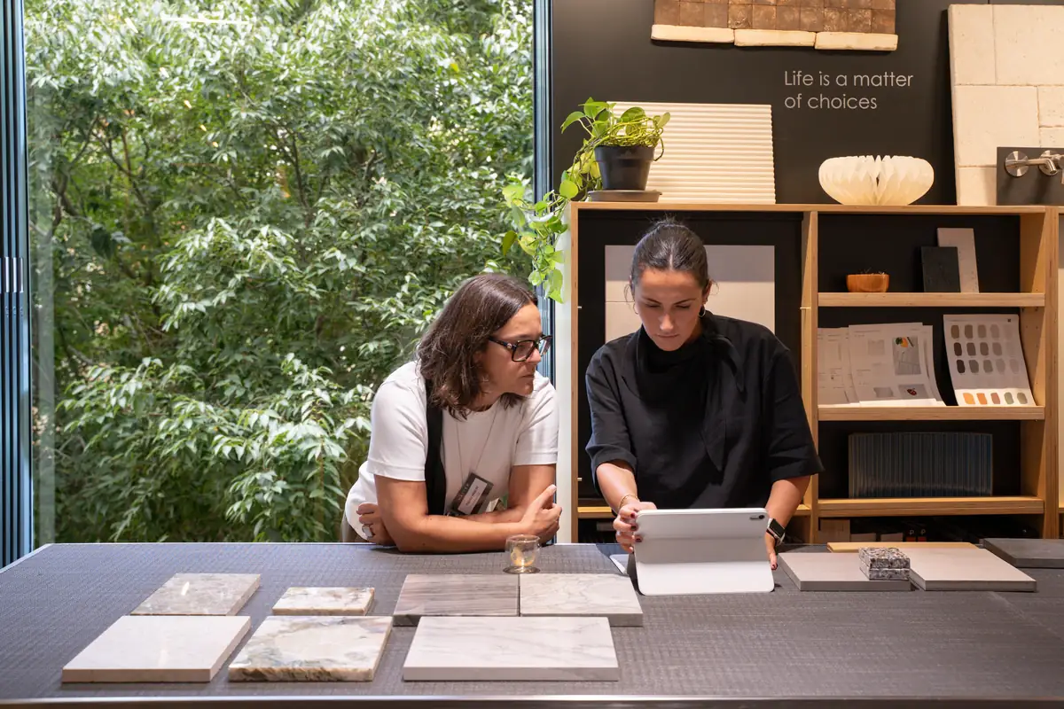 Two women look at a tablet beside marble samples in the Materials Library at Matter Barcelona.