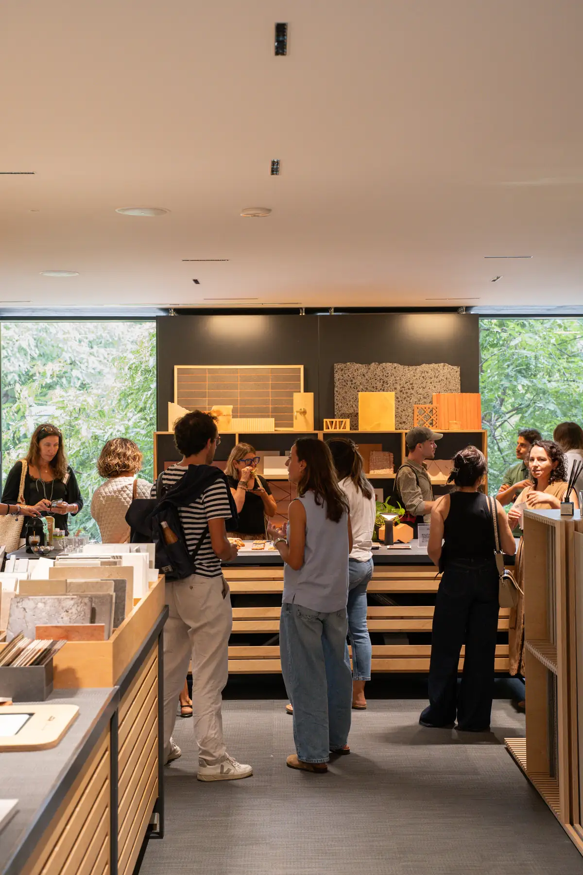 Attendees talking on their feet in the Materials Library at Matter Barcelona, with material samples in the background and windows onto greenery.