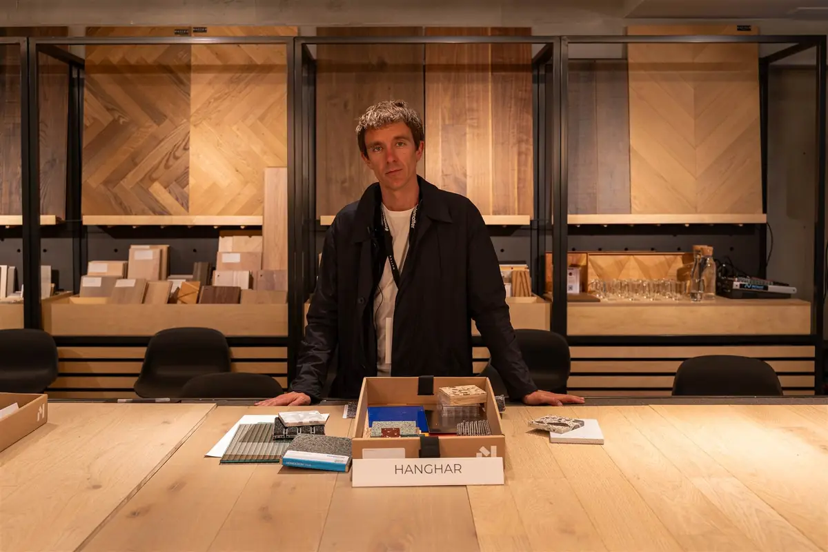 Eduardo Mediero standing behind the HANGHAR sample box, with sheets and samples on the table