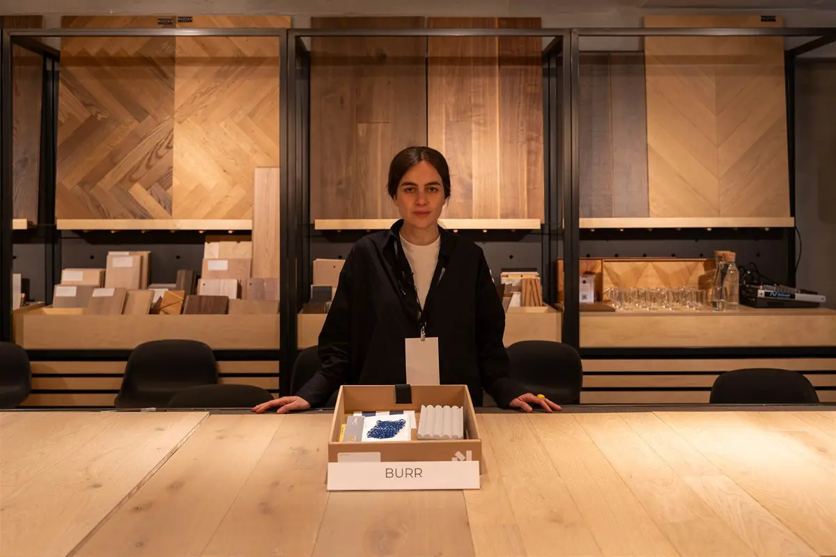 Elena Fuertes standing behind the BURR sample box, with blue and white textile samples