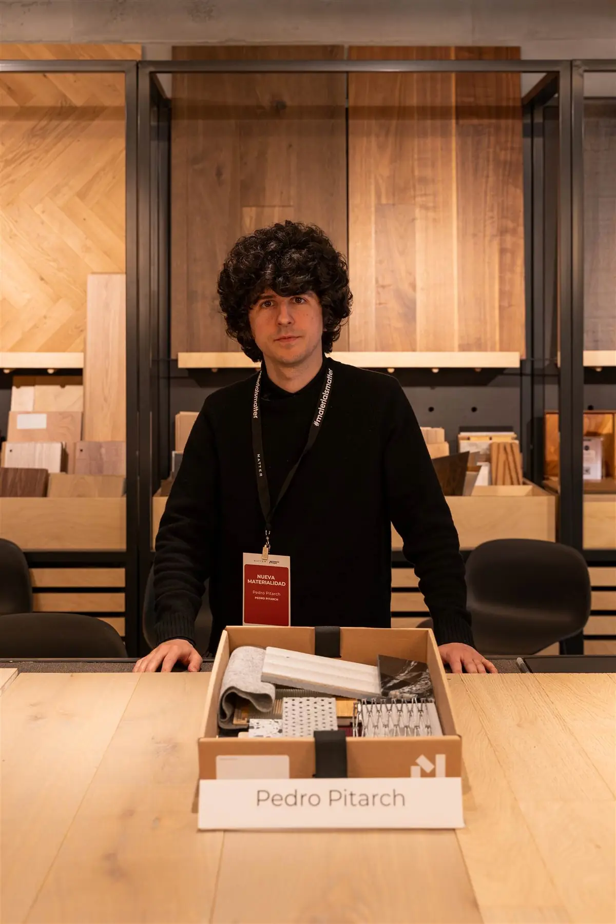 Pedro Pitarch standing behind his sample box, in front of a wooden display unit
