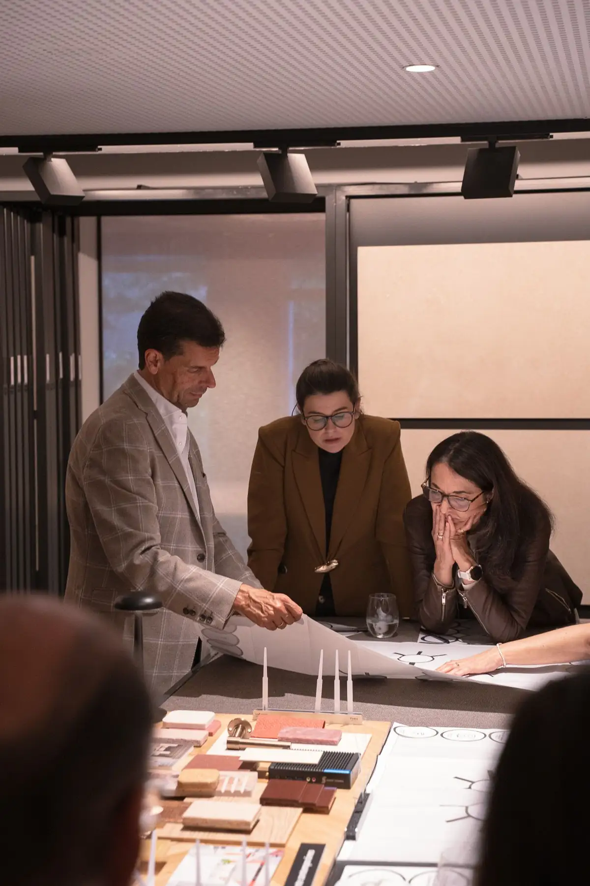 Tres participantes revisan el mapa de su mesa junto a muestras de materiales