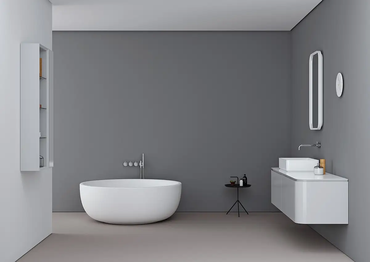 Baño gris con bañera exenta blanca, mueble suspendido blanco con lavabo sobre encimera y espejo vertical