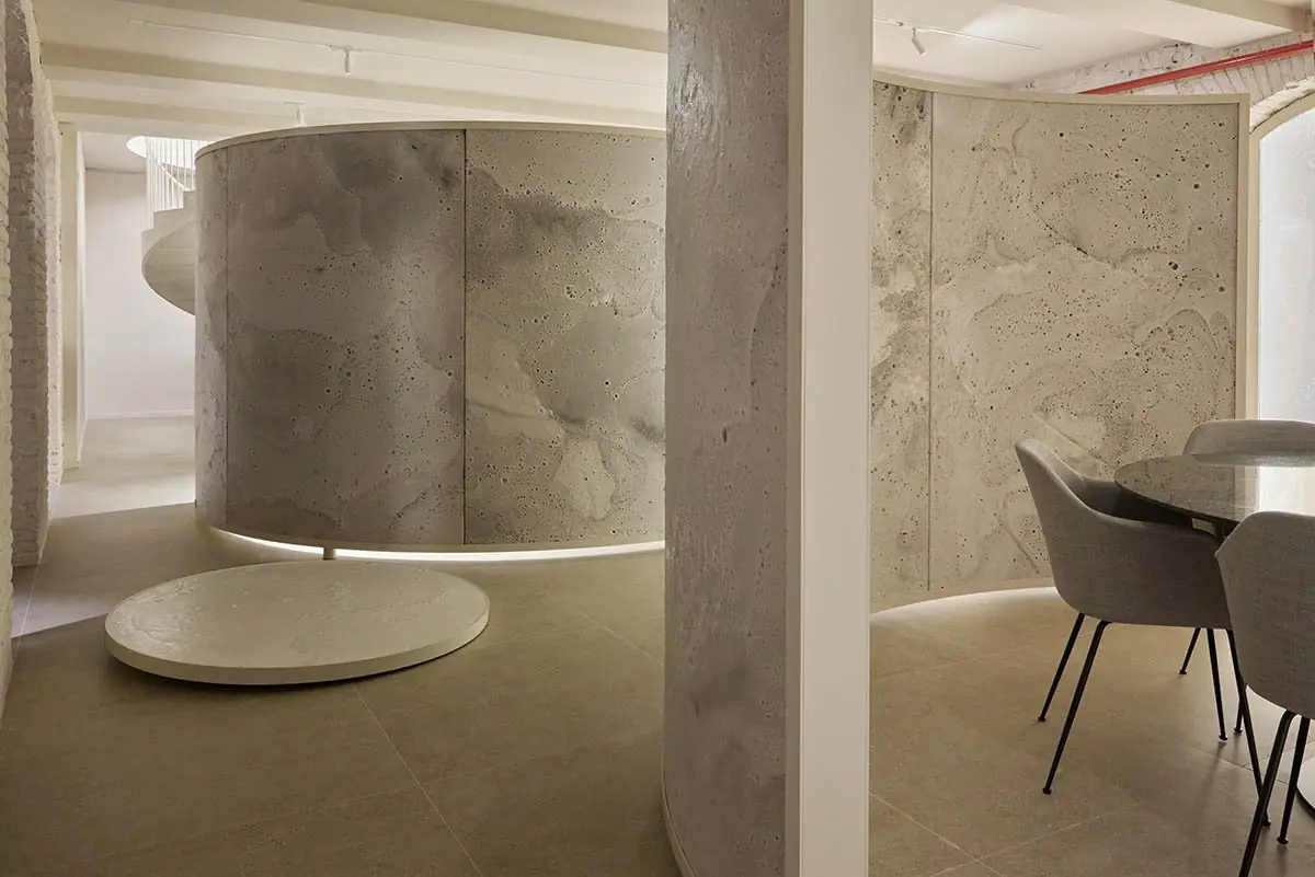 Cylindrical volume of textured white material on a circular base, next to a column