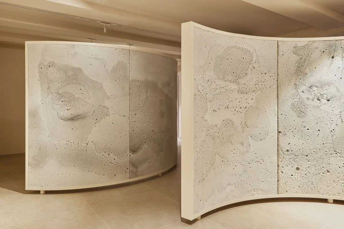 Two large curved screens with a textured white surface in a low-ceilinged room