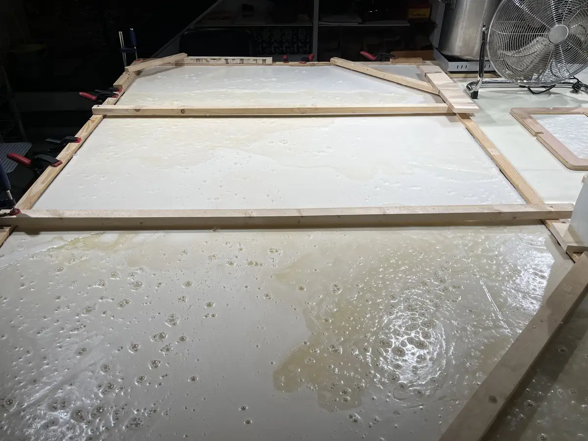 Wooden frames with white foam spread out on a workshop floor