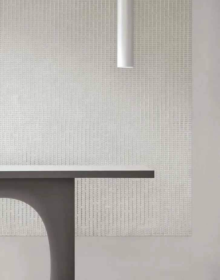 Detail of a light-toned Matter Uren panel, with rectangular tesserae of various lengths, next to the edge of a console.