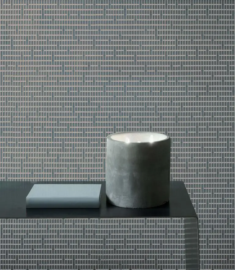 Wall and unit front clad in Matter Uren in a bluish grey, with a candle and a book on the worktop.