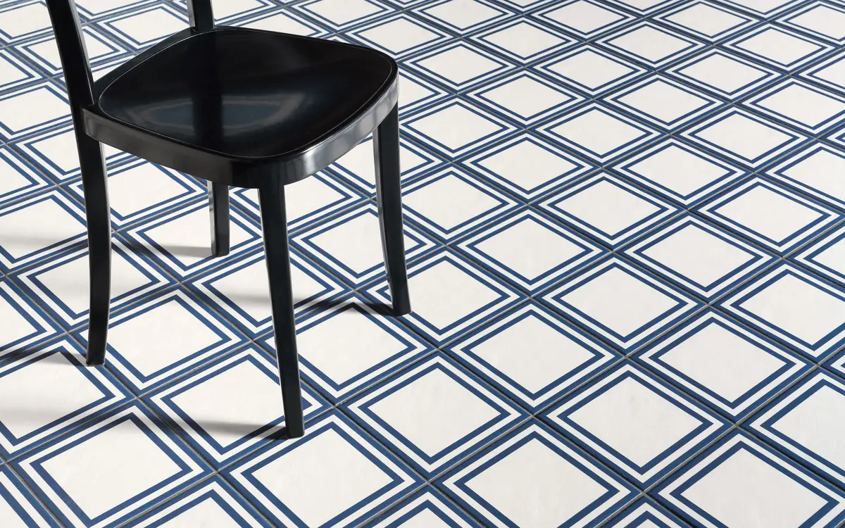 Black chair on a floor of white tiles with a double blue frame forming a grid of diamonds