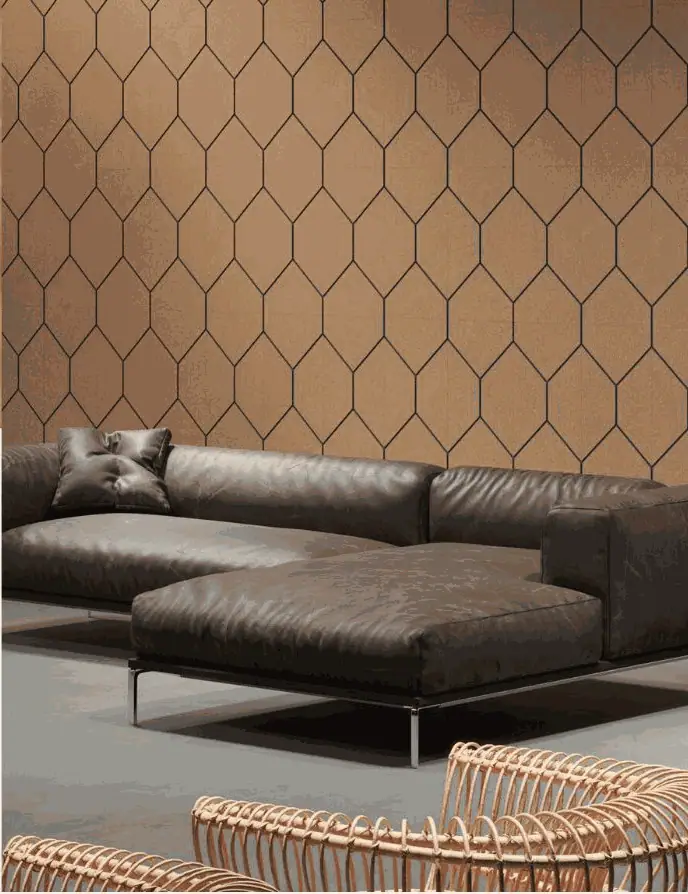 Sofá de piel oscuro ante una pared revestida de placas de corcho Groovy con motivo hexagonal alargado