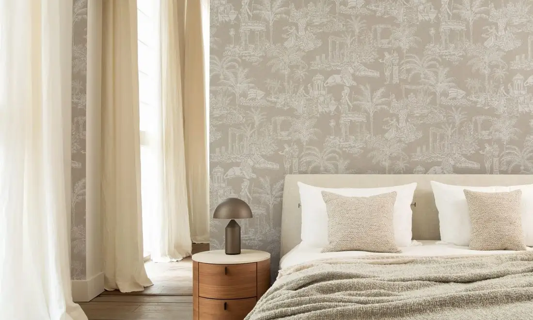 Bedroom with a wall of light grey wallpaper with temples, palm trees and classical figures drawn in white