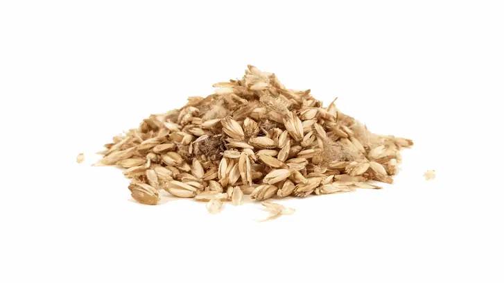 Pile of spelt husks on a white background