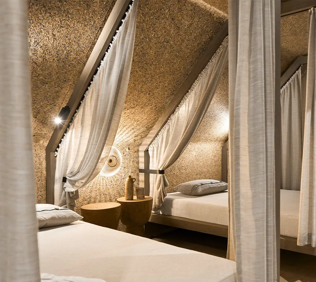 Attic bedroom with canopy beds and walls and ceiling covered with a plant-fibre surface