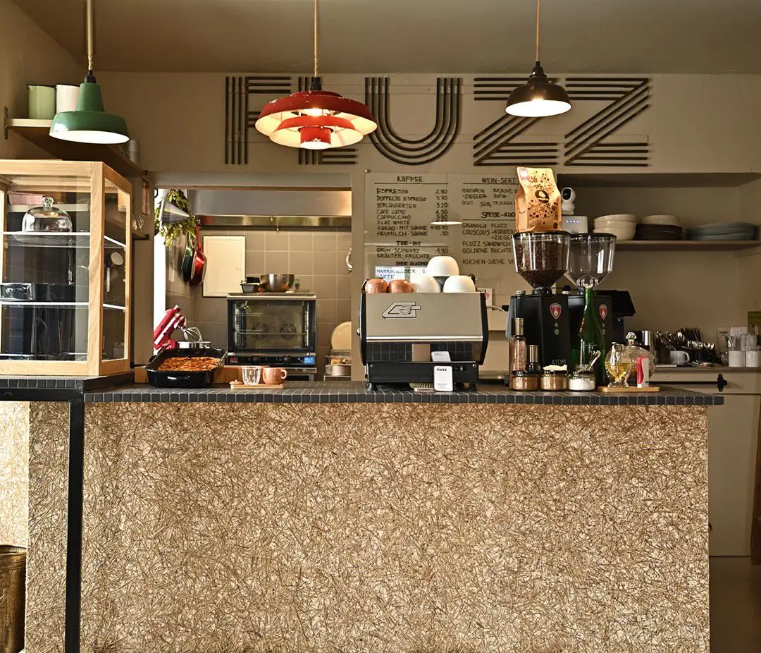 Café counter covered with a lavender-stem surface, with a coffee machine and pendant lamps