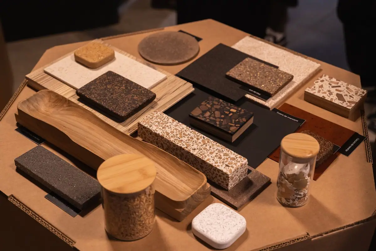 Cardboard table with samples of terrazzo, fibre agglomerates, wood boards and jars of organic waste