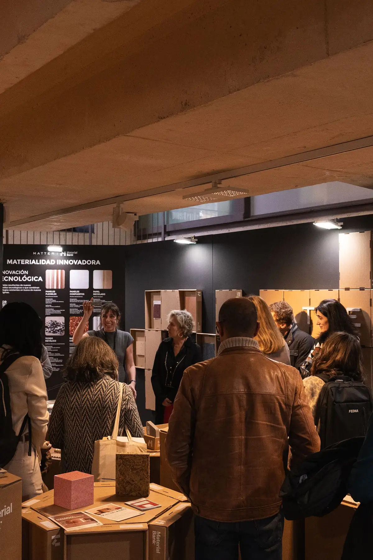 A guide points to the Technological Innovation panel in front of a group of visitors