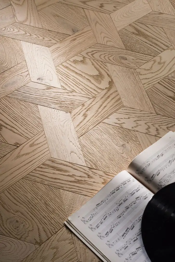 Light wood flooring in the Casablanca format, with interlocking geometric pieces, a music score and a vinyl record