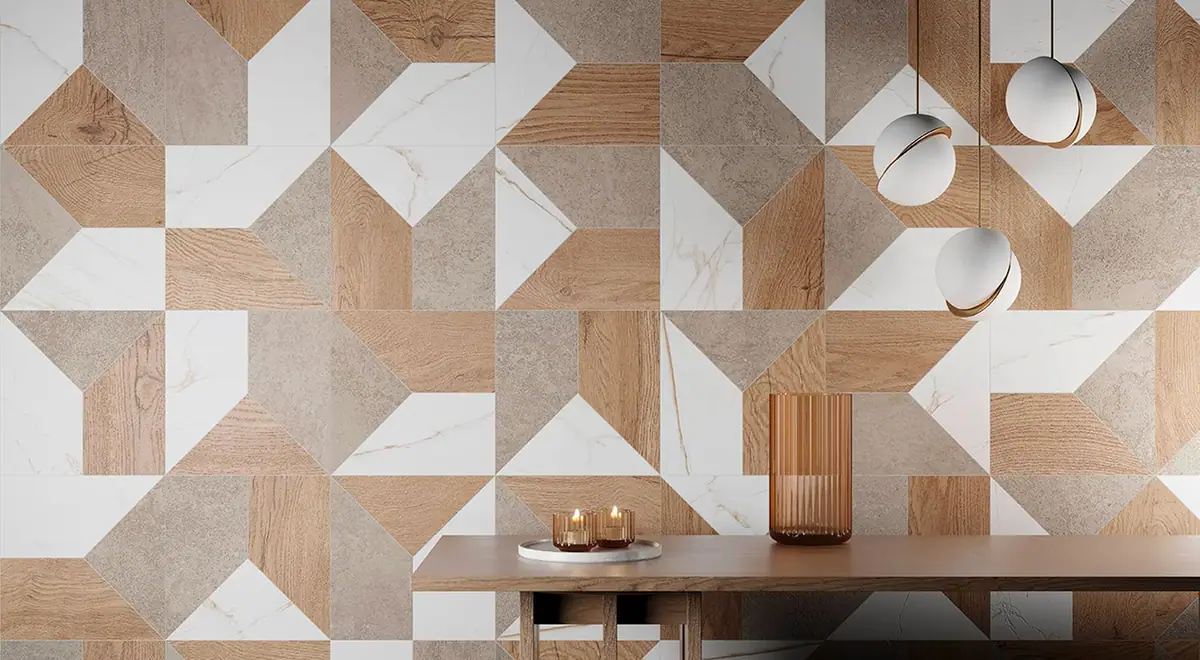 Pared revestida con un patrón geométrico de piezas efecto piedra, mármol blanco y madera, con una mesa y lámparas esféricas