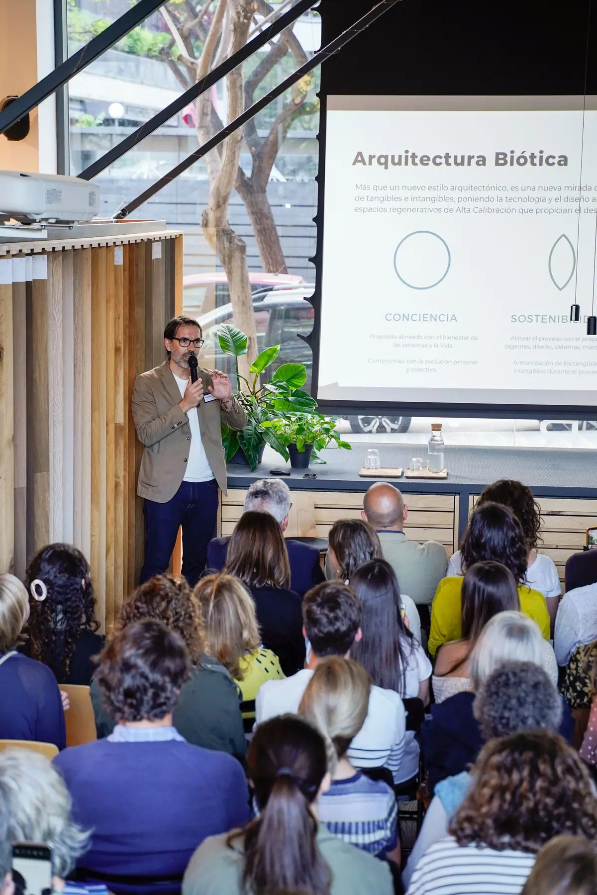 Speaker beside a slide titled Arquitectura Biótica, in front of the audience