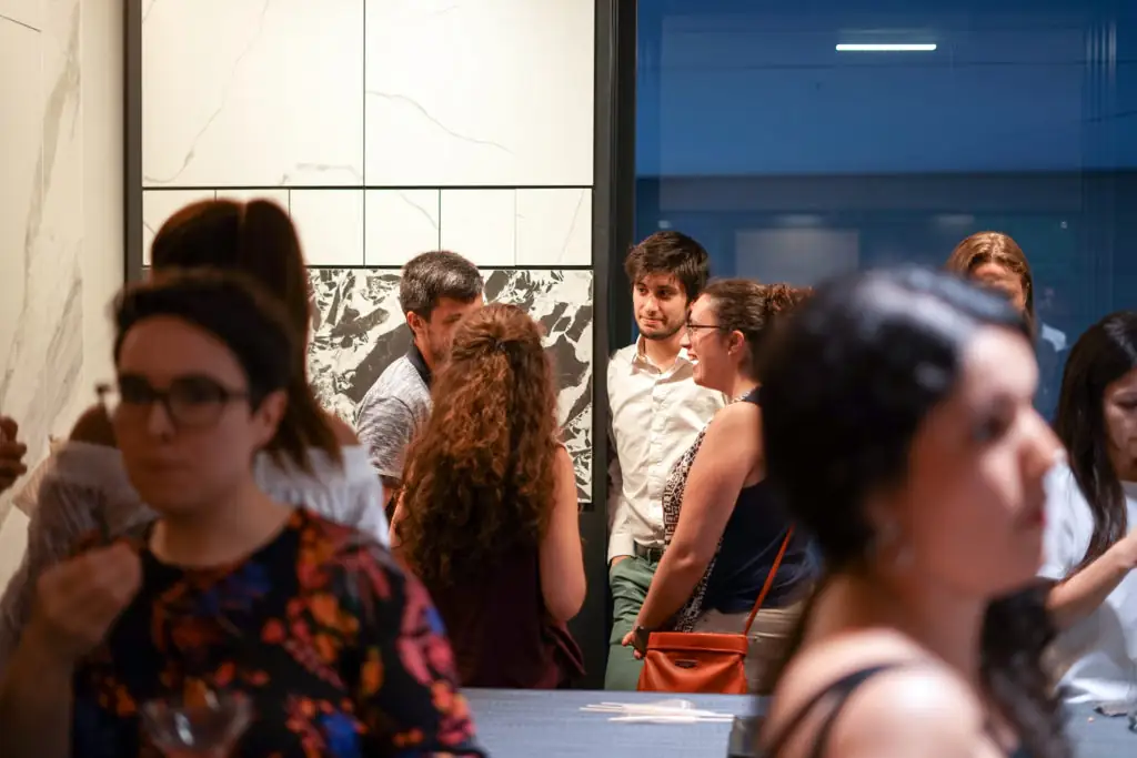 Asistentes conversando entre paneles de materiales del showroom