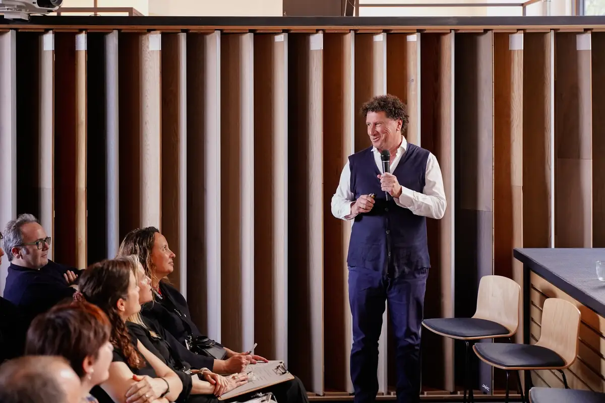 Federico Turull speaks into a microphone, standing in front of the audience