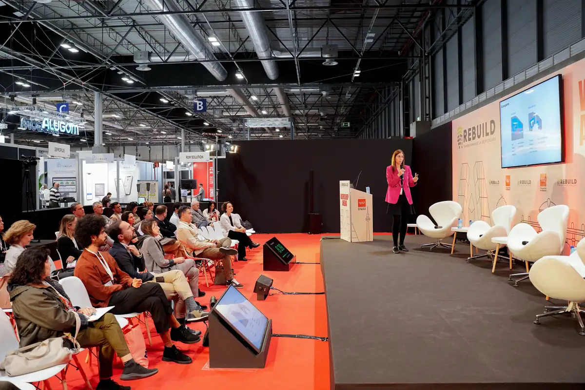 Una ponente presenta su proyecto de pie ante el público del Workshop Arena
