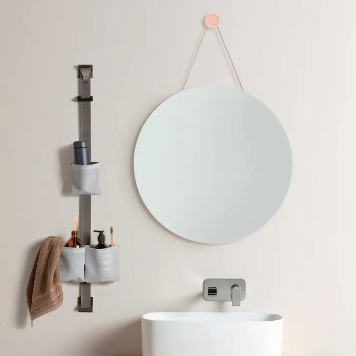 TAPE STORAGE strap next to a washbasin, with grey pouches holding toiletries and a hanging towel