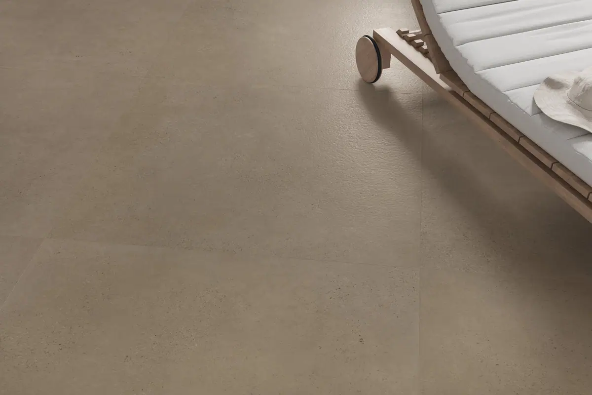 Taupe cement-effect porcelain floor next to a wooden sun lounger