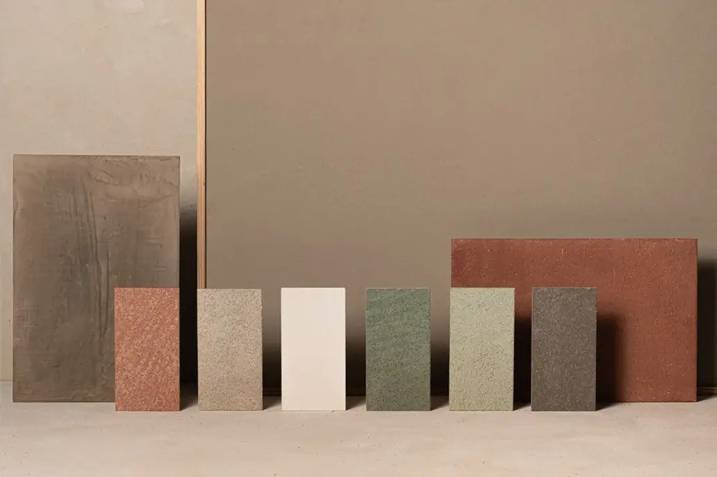 Lime coating samples in earth, sand, green and grey tones leaning against a wall