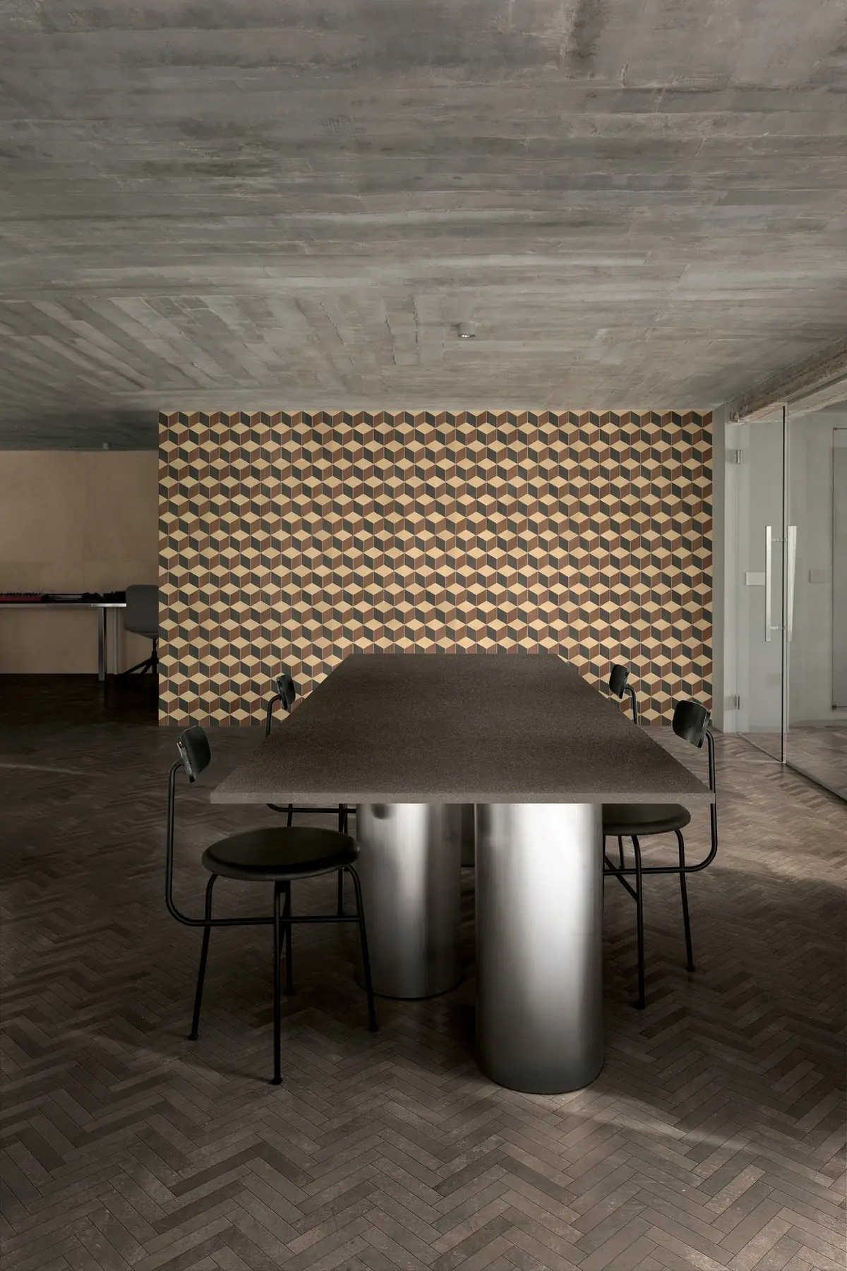 Meeting room with a wall of earth-toned diamond mosaic and a dark herringbone floor