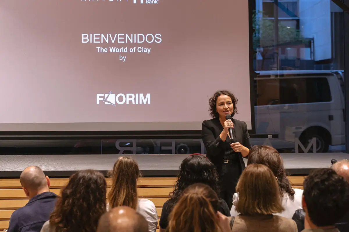 Host with a microphone in front of the welcome screen for The World of Clay by Florim