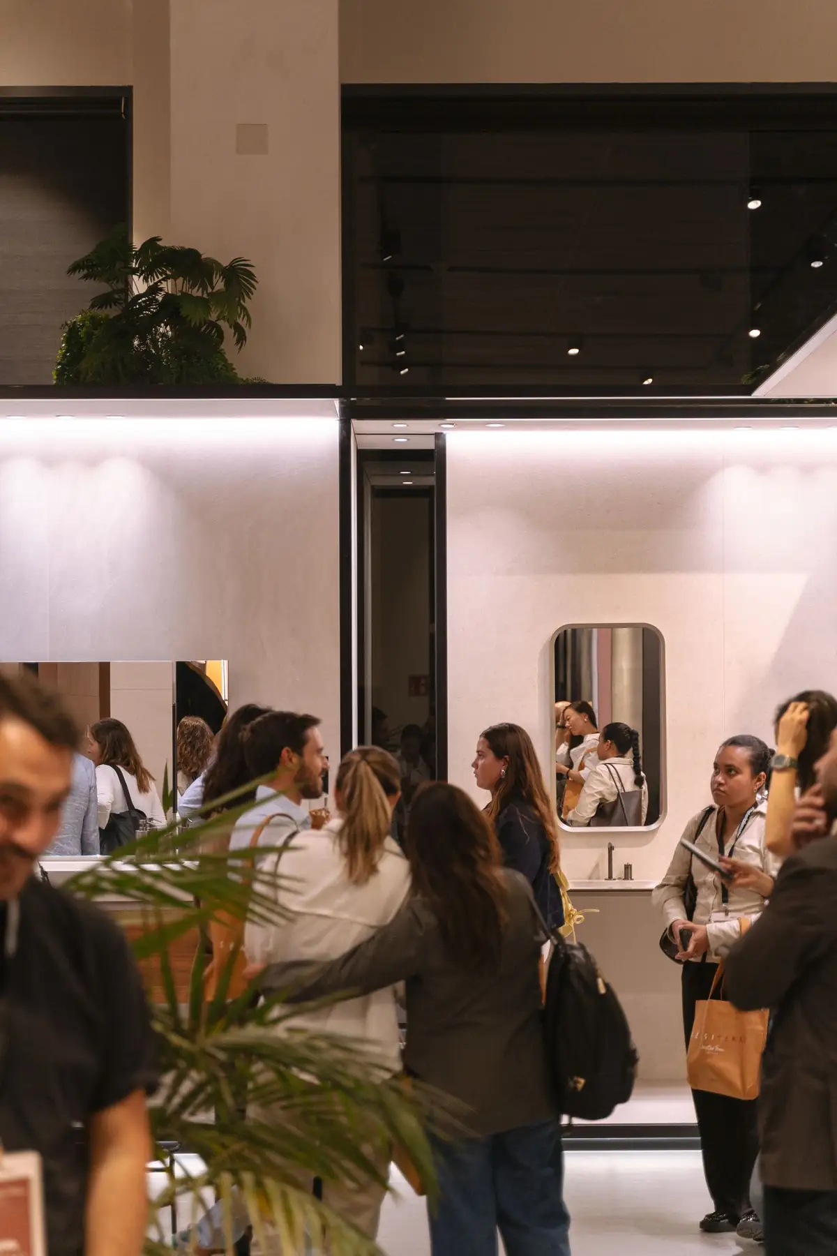 Guests walking through the Florim space, with ceramic-clad bathroom settings