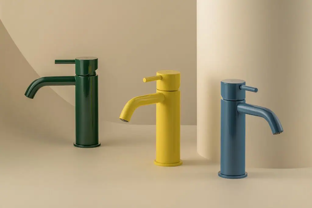 Three single-lever basin mixers in green, yellow and blue on a beige background
