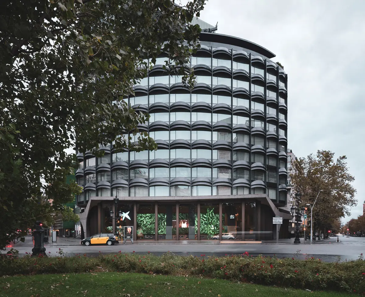 Curved façade of the building on plaza Francesc Macià with the All in One entrance on the ground floor