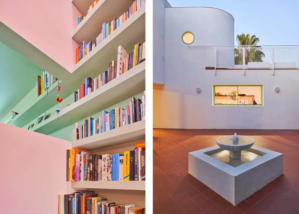 Estantería de obra con libros entre paredes rosa y verde, junto a un patio con fuente revestida de gresite