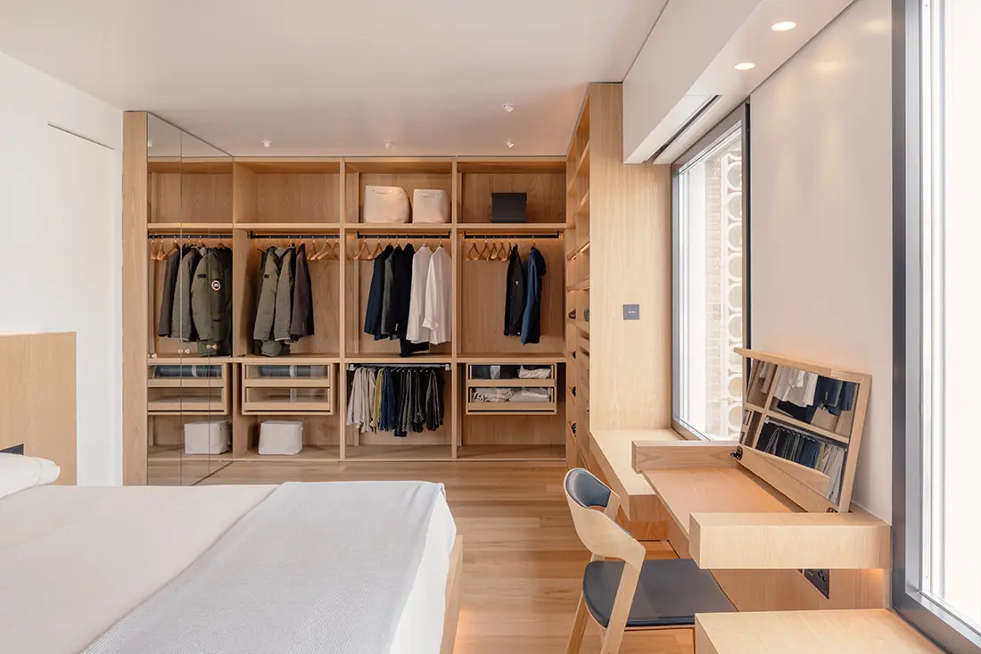 Dormitorio con vestidor abierto de roble y tocador junto a la ventana