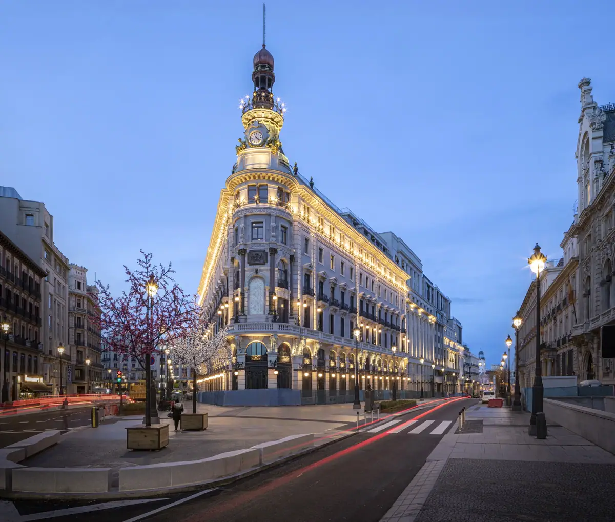 Edificio de esquina con torre y cúpula del Centro Canalejas iluminado al anochecer en la calle Alcalá
