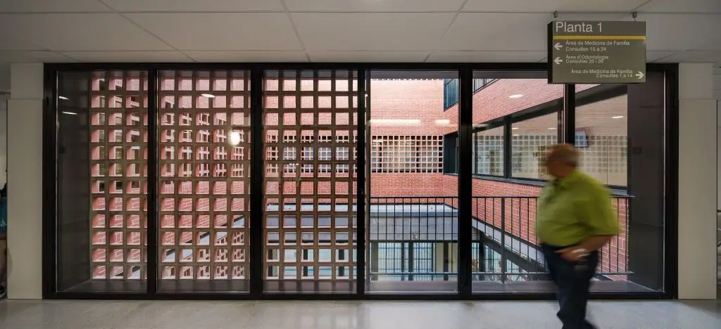 First-floor corridor with a large window through which the ceramic latticework of the courtyard can be seen
