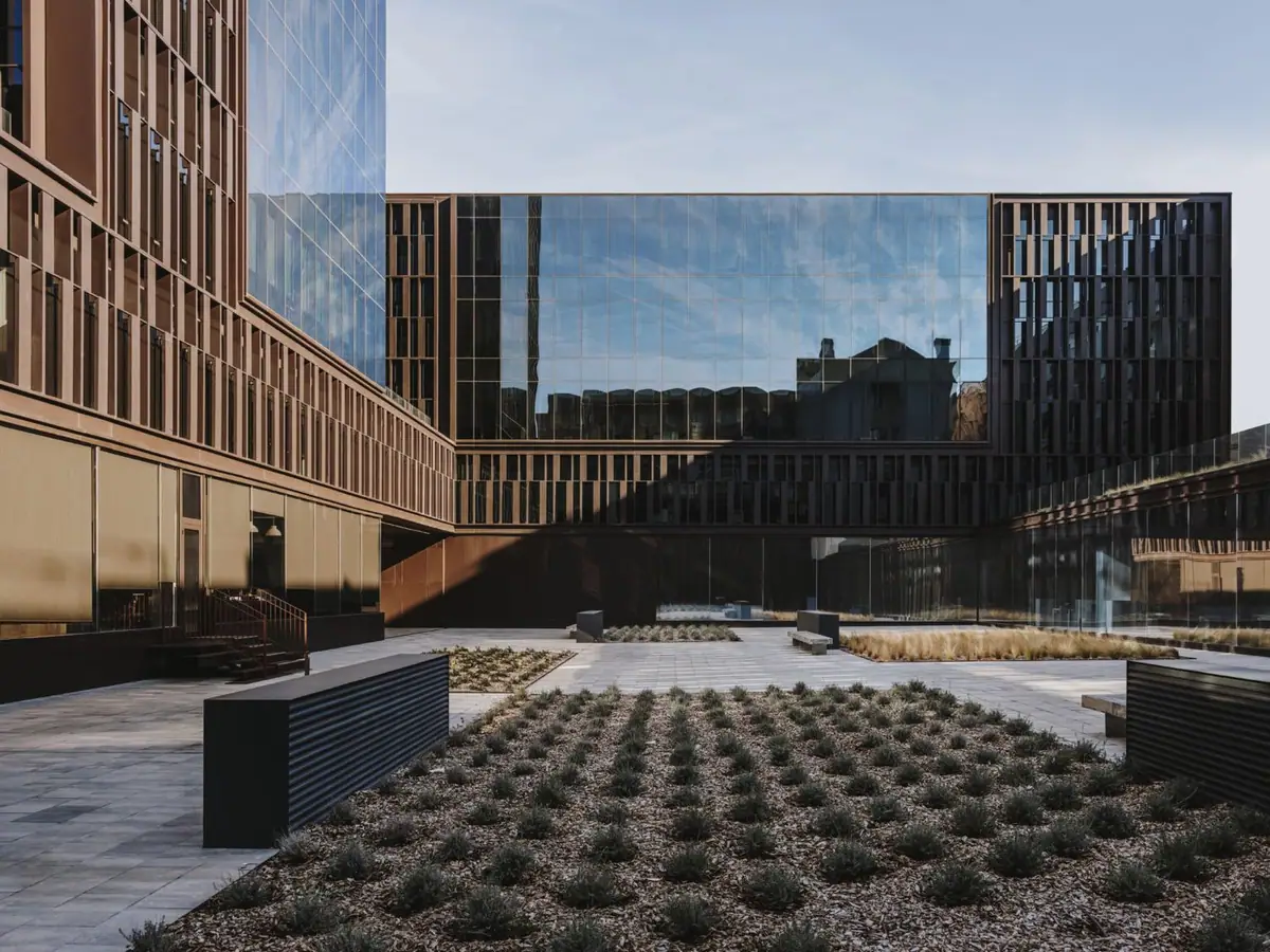 Central courtyard of Platinum@BCN with low planted beds, benches and façades of glass and aluminium louvres
