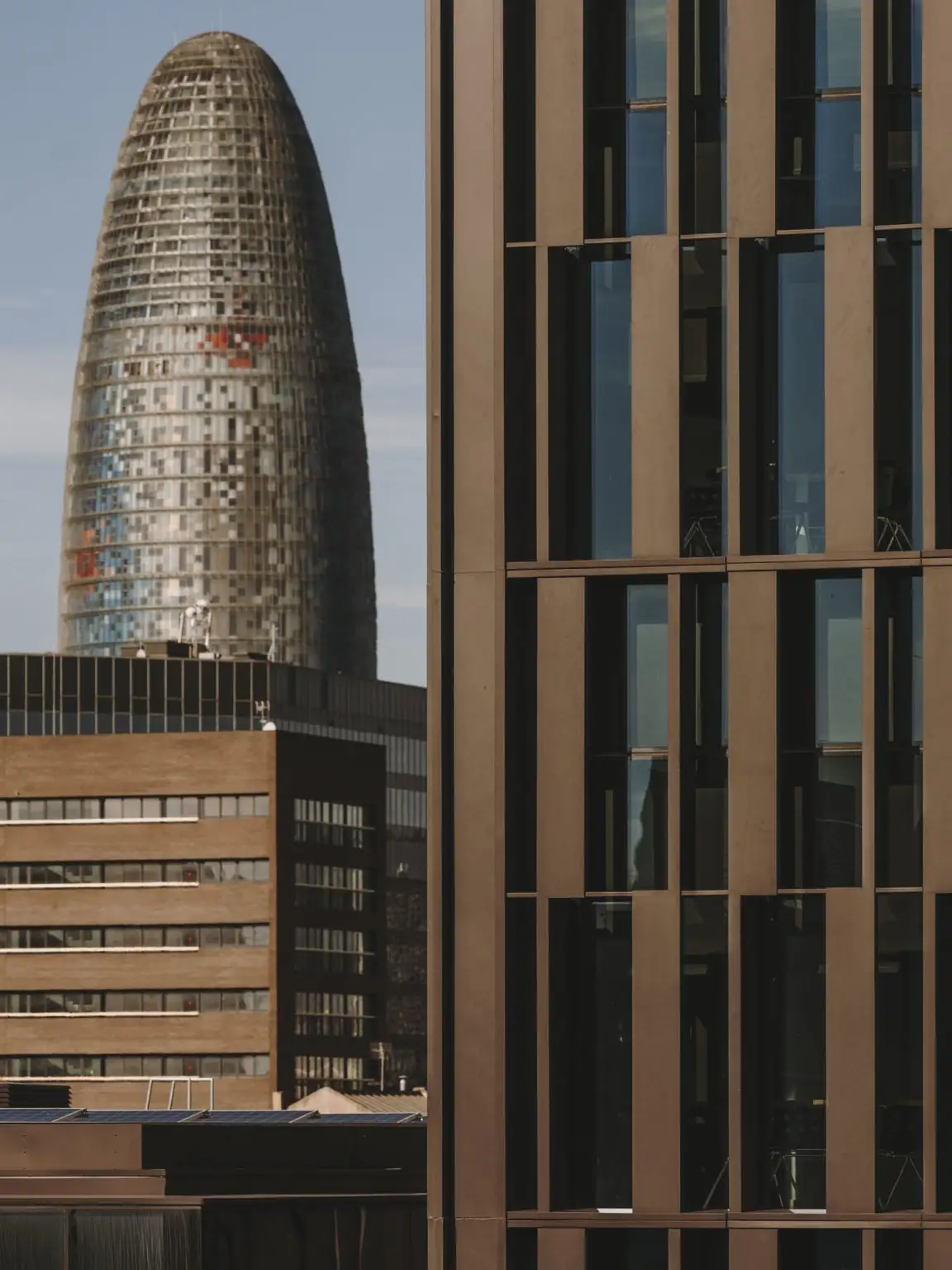 Detail of the bronze-coloured aluminium louvre façade with the Glòries tower in the background