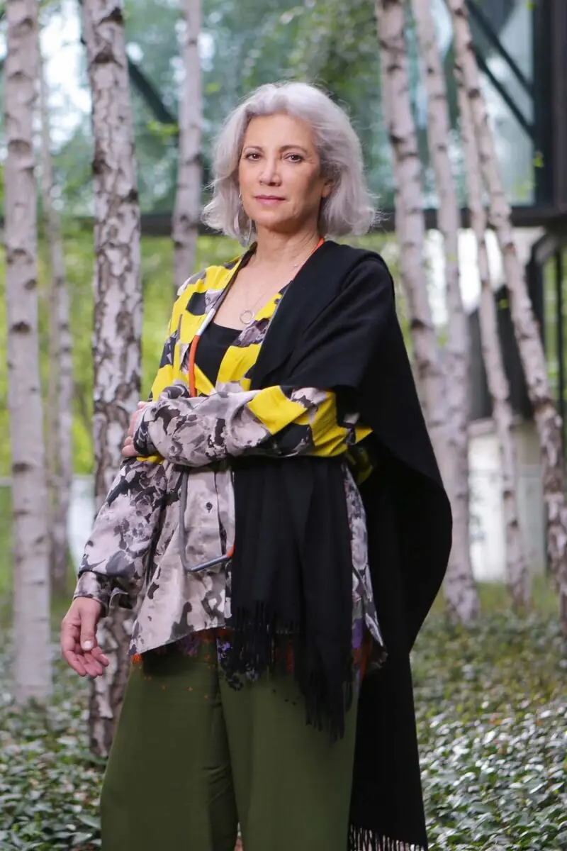 Portrait of the architect Carme Pinós standing among birch trees