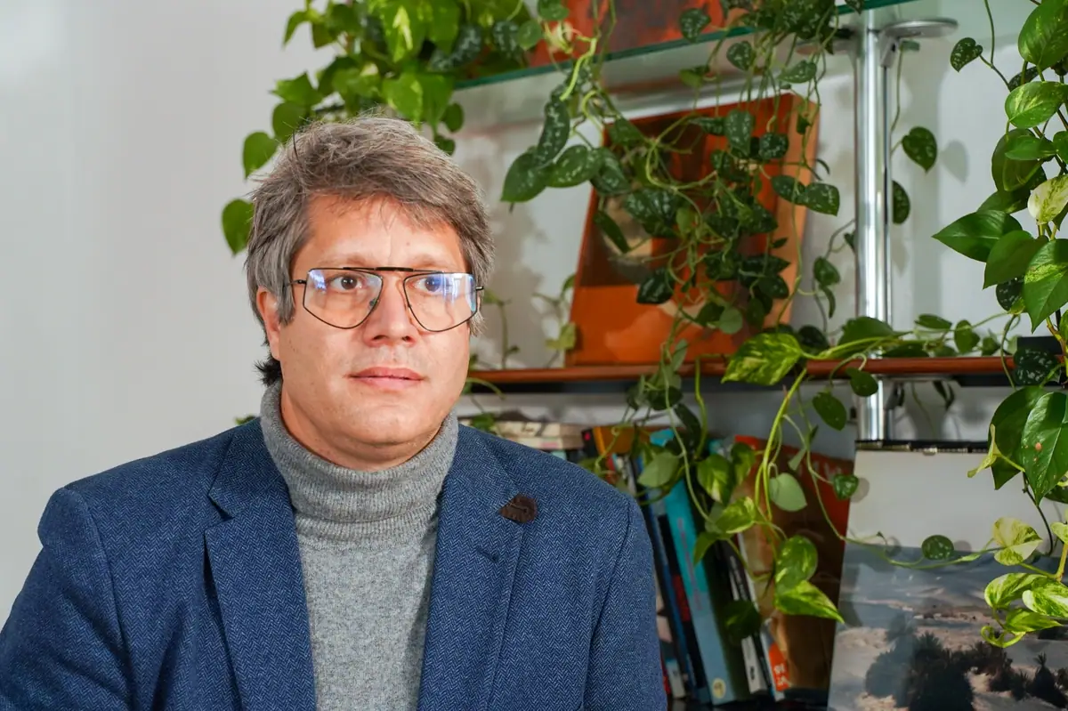 Retrato de Marc Chalamanch durante la entrevista, con jersey de cuello alto y plantas al fondo
